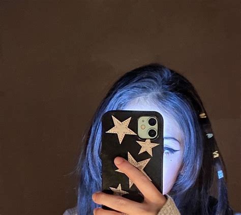 A Girl With Blue Hair Is Holding Up Her Phone To Show The Stars On It