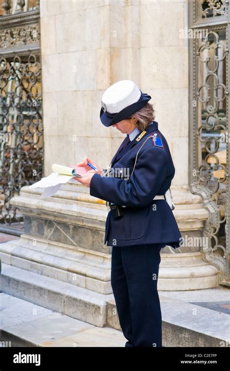 Female Police Officer Writing A Parking Ticket In Siena Italy Stock