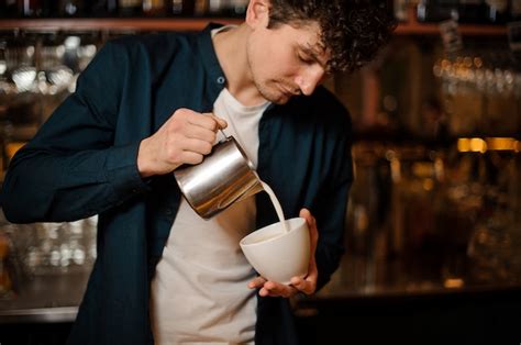 Premium Photo Barman Pouring Some Milk From Pitcher Into A Cup