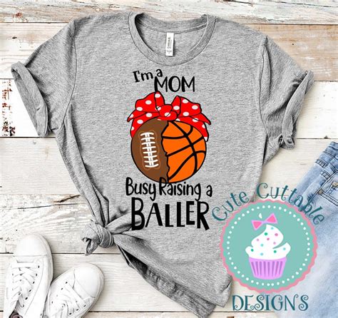 A Shirt That Says I M A Mom Busy Raising A Baller With A Cupcake On It