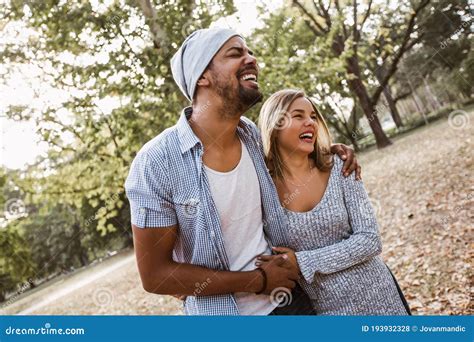 Portrait Of Romantic And Happy Mixed Race Young Couple In Park Stock