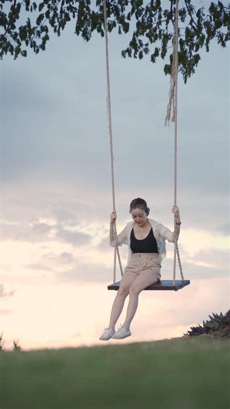 Attractive Asian Woman Tourist Happy Playing Swing Under Big Tree In