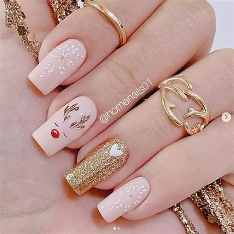 A Woman S Hand With Gold And White Manies On Her Nails Including Rings