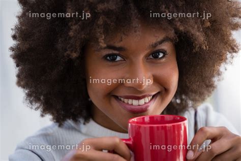 Close Up Portrait Of Smiling Woman With Frizzy Hair Holding Coffee Mugの写真素材 [89192749] イメージマート