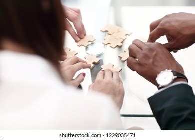 Hands Multiethnic Team Assembling Jigsaw Puzzle Stock Photo