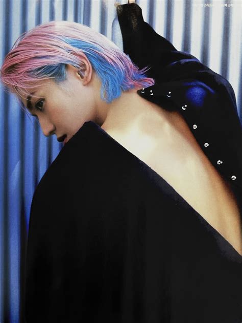 A Woman With Pink And Blue Hair Standing In Front Of A Metal Wall