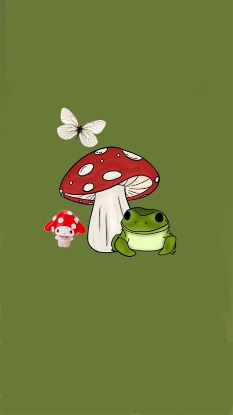 A Green Frog Sitting Next To A Red Mushroom On Top Of A Green Field