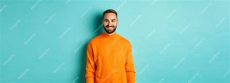 Free Photo Lifestyle Handsome Man In Orange Sweater Smiling At Camera