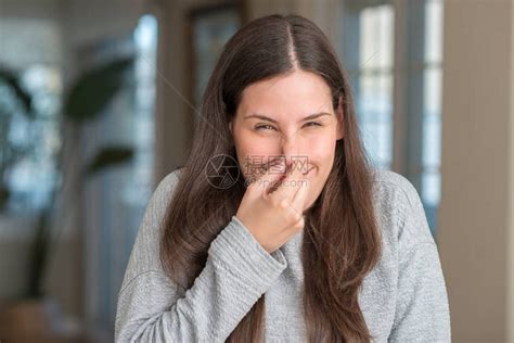 年轻漂亮的女人在家里闻到一些难闻的令人作呕的难以忍受的气味高清图片下载 正版图片503092199 摄图网