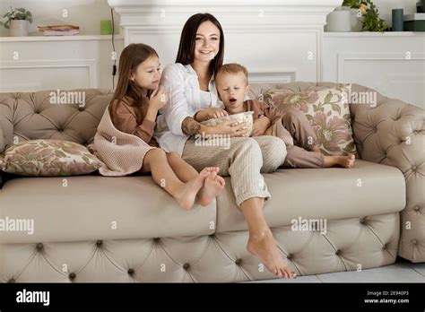 Maman S Assoit Sur Le Canap Avec Son Fils Et Sa Fille Et Regarde Un