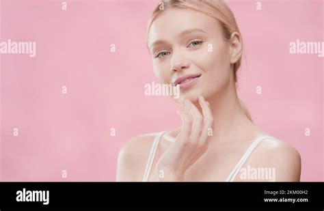 Woman With Light Hair In Ponytail Touches Jawline Turning Body Stock