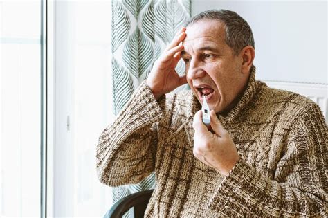 Um Homem Est Sentado Em Frente A Uma Janela Um Dispositivo Que Diz