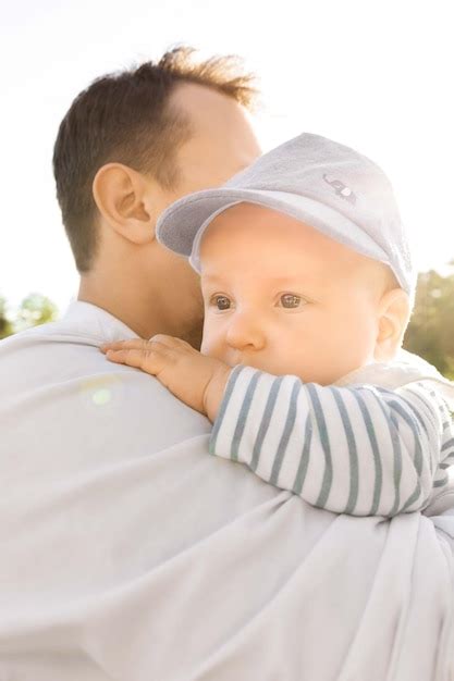 Padre Sosteniendo A Su Hijo En Sus Brazos Sobre Un Fondo De Vegetaci N