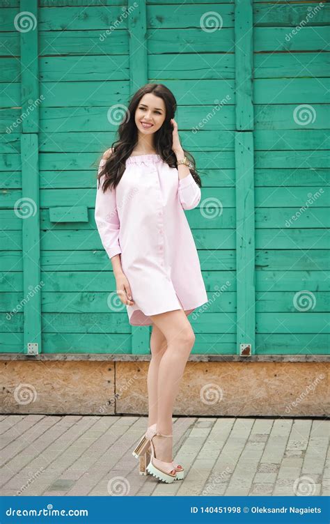 Mooie Glimlachende Vrouw Het Brunette Loopt Onderaan De Straat In Een Roze Korte Kleding Stock