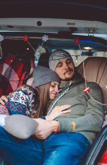 Premium Photo Young Couple Embracing While Sitting At Car Trunk