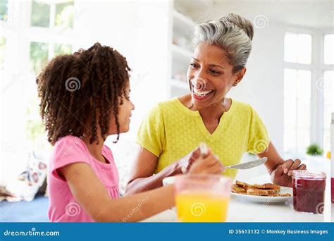 Grandmother With Granddaughter Laughing Together On Sofa Royalty Free