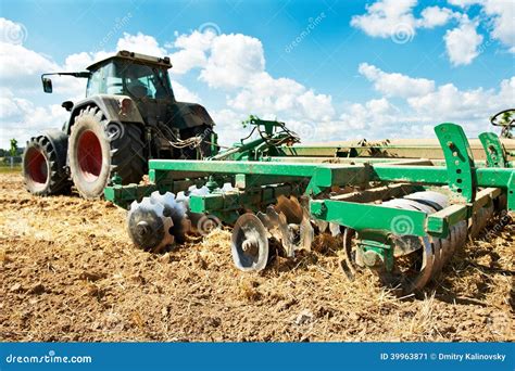 Tractor De Arado En El Trabajo Del Cultivo Del Campo Imagen De Archivo