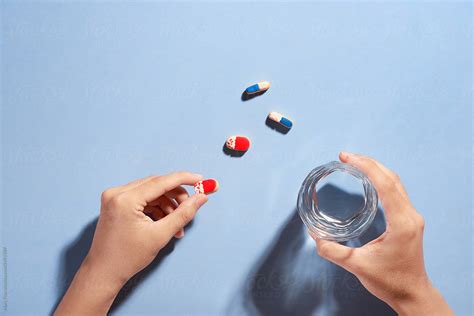 Male Hand Holding Small Pill And Glass Of Water By Stocksy Contributor Marc Tran Stocksy