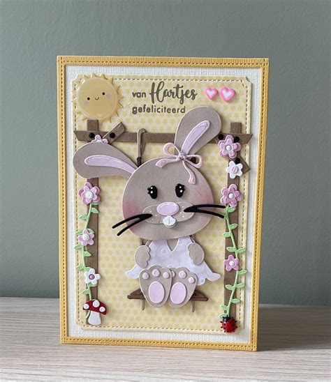 A Handmade Card With A Bunny Sitting On Top Of A Wooden Table Next To A