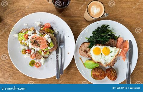 Breakfast Meals with Eggs, Fish and Vegetables on Plates Near Cups of ...