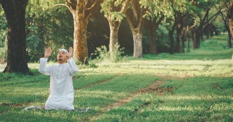 Homem muçulmano religioso tradicional kandura orando ao ar livre em