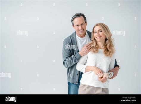 Portrait Of Smiling Stylish Mature Man And Woman On Grey Stock Photo