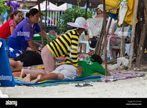 Tourists Enjoying A Traditional Thai Massage On The Beach Of Patong On