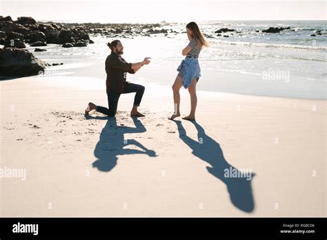 Man Kneeling And Proposing To Woman By The Sea Man Making Marriage