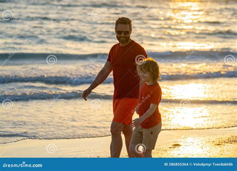 Father And Son Holding Hands Walking On Sunset Beach Father And Son