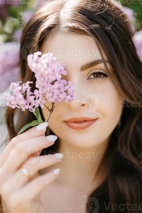 Young Girl Bride In A White Dress In A Spring Forest In Lilac Bushes