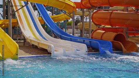 Waterslide in aquapark outdoor. Childs having fun in waterslide in ...