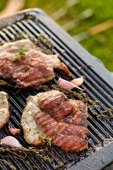 Grilled Pork Neck With Herbs And Garlic On A Cast Iron Grill Plate