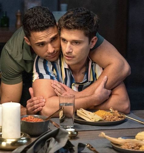 Two Men Sitting At A Table With Plates Of Food