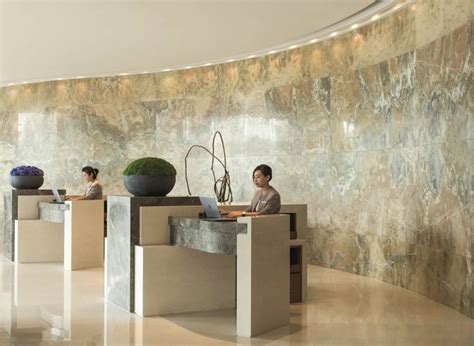 Two Women Are Sitting At Tables With Vases On The Wall In Front Of Them