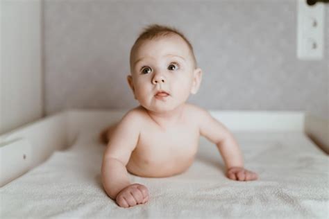 Premium Photo The Naked Baby Lies On Its Tummy And Learns To Hold Its