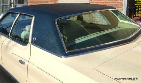 An Old Car Parked In Front Of A Brick Building With The Sunroof Open