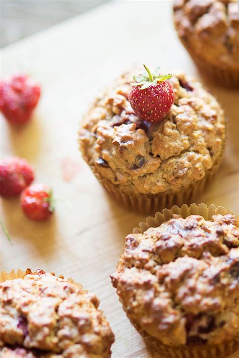 Some Muffins Are Sitting On A Table With Strawberries