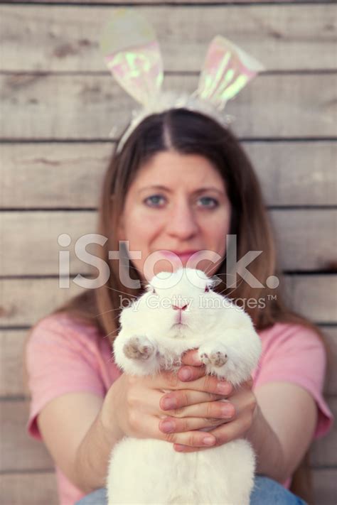 Beautiful Young Woman With Bunny Ears Holding A Rabbit Stock Photo