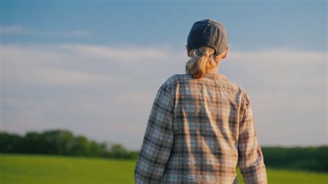 Vídeo Premium Vista trasera de una agricultora caminando entre campos