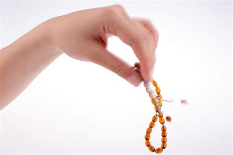 Premium Photo Cropped Hand Holding Prayer Beads Over White Background