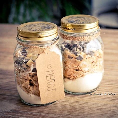 Two Glass Jars With Cookies And Other Items In Them On A Table Next To