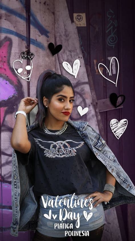 A Woman In Black Shirt And Jean Jacket Standing Next To Wall With