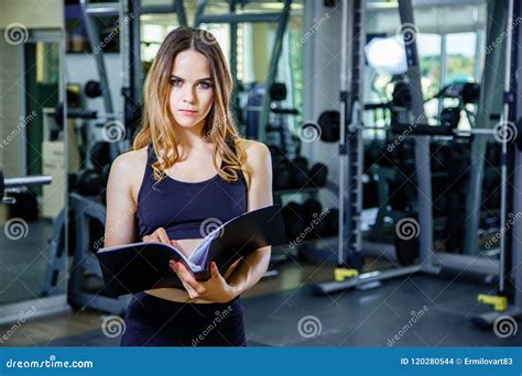 Personal Trainer Woman Holding Clipboard With Training Plan In Gym