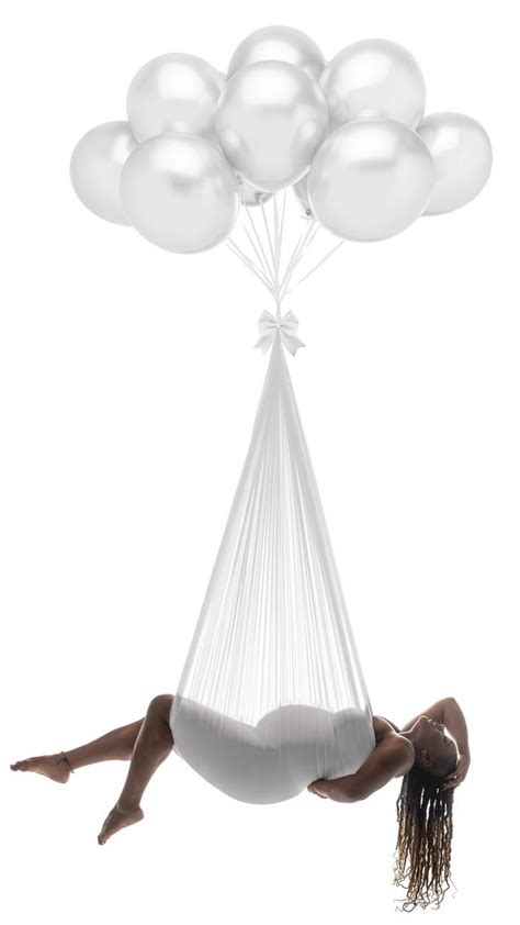 A Woman Laying In A Hammock With White Balloons