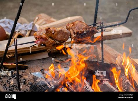 Process Of Cooking Large Meat Peaces On Spit Over Open Fire Stock Photo