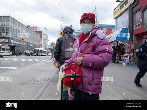 An Older Chinese American Woman Out Shopping Waits For A Bus On Main