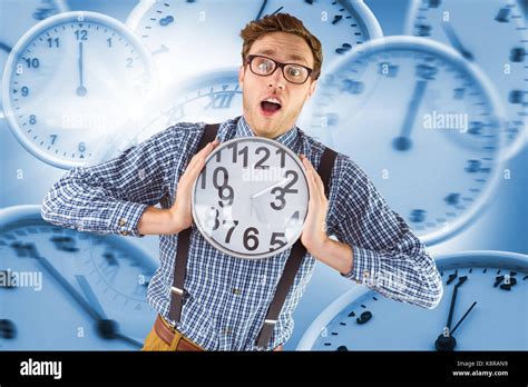 Geeky Businessman Holding A Clock Against Computer Generated Image Of