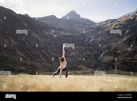 Woman Doing Yoga Triangle Pose With Bent Knee In An Alpine Meadow