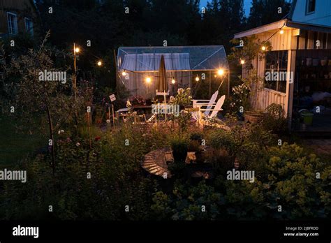 Garden with fairy lights at night Stock Photo - Alamy