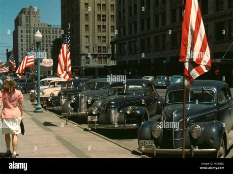 Us-Flaggen angezeigt, an einer Hauptstraße in den USA. 1940s Era Autos entlang der Straße ...